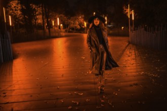 Girl in a hat walking calmly through a park on a winter night. Enjoying the solitude of the night