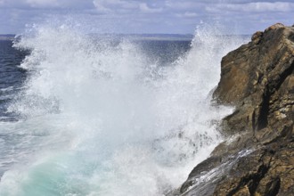 Waves crashing into rocks of cliff along the Brittany coast, France, Europe