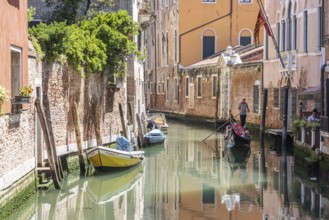 Venetian gondola with gondolier travelling on the canals of Venice, Venice, Italy, Europe