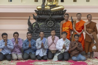 Monks and Laotians in front of a Buddha statue, Bhumispara-mudra, Buddha Gautama at the moment of