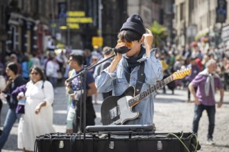 Street musician with electric guitar and microphone, world's largest cultural festival The Fringe,