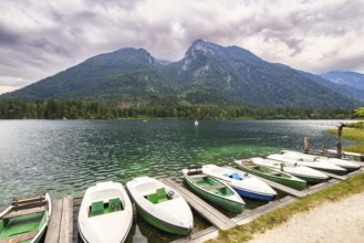 Jetty with boats at Hintersee, with green mountains in the background, peaceful and idyllic natural