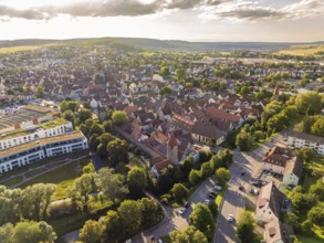 Aerial view of a busy city centre with red roofs and green trees in the early evening, Weil der