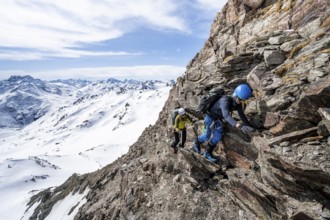Two mountaineers climbing up a narrow mountain path, ascent to the summit of Piz Grialetsch in