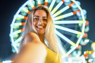 Personal perspective of a cute woman taking selfie in a fair at night