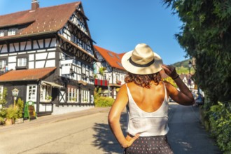 A female tourist from behind in the medieval mountain village of Sasbachwalden, Black Forest,
