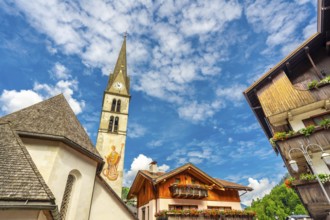 Picturesque view of alleghe village in the italian dolomites, featuring a church tower, traditional