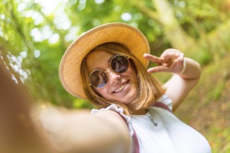 Personal point of view of a beauty young caucasian woman gesturing success with fingers while