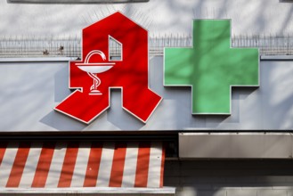 Pharmacies are systemically relevant in the corona crisis, red logo and green cross on the facade