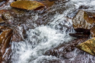 Small stream with its waters running over rocks in Minas Gerais, Minas Gerais, Brazil, South