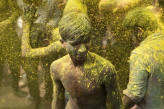Revellers dancing in the beat of music as they celebrate Holi on a street, the Hindu spring