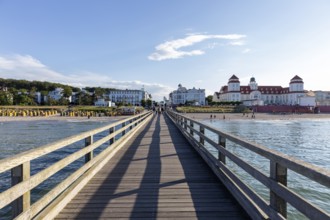 View along a wooden bridge to buildings and the blue sky with few clouds, Rügen, Binz