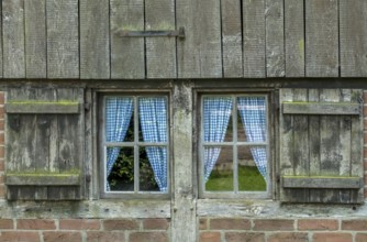Old wooden window with blue curtains and weathered shutters, Münsterland, North Rhine-Westphalia,