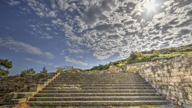 Stone staircase in an ancient ruin under a sunny sky with clouds, historical site, Kamiros,