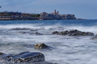 Rocky beach and gentle waves in the Mediterranean near Giovinazzo in the province of Bari.