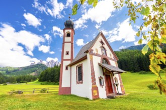 Charming st. Magdalena church nestled in a green meadow, with the majestic odle mountains and lush