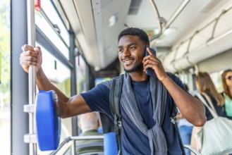 African entrepreneur talking on the phone on his way to work on the bus