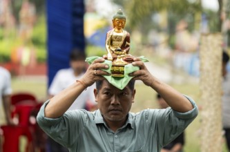 NAMSAI, INDIA.- APRIL 16: A devotees carries the idol of Lord Buddha as he celebrate the vibrant