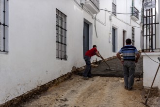 Construction workers renew asphalt surface in a small street, Vejer, Andalusia, Spain, Europe