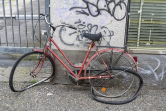 A completely destroyed and demolished bicycle parked against a house wall, Baden-Württemberg,