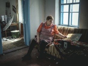 Irina in her small house on the front line, most of it destroyed by shelling, in winter she heats a