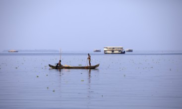 Fisherman on a small boat on the Vembanad Lake, canal system of the backwaters, Kerala, India, Asia