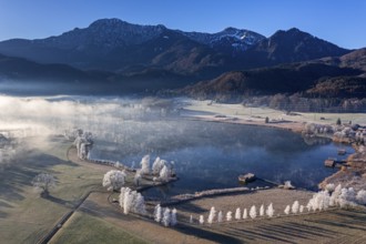 Aerial view of a lake in front of mountains in winter, hoarfrost, morning light, view of