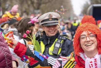 Rose Monday parade in Düsseldorf, policemen on duty at the street carnival, with flower