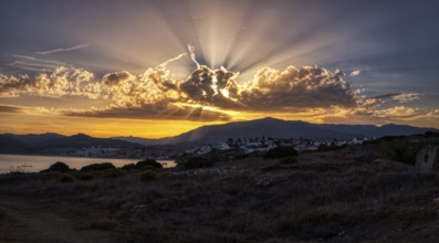 Dramatic sunset over mountains and coast with radiant light through clouds, Algeciras