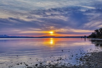 Idyllic sunset over the lake with colourful clouds and reflecting water, Chiemsee
