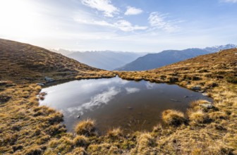 Small mountain lake on the Krahberg, sun star in the morning, mountain panorama in autumn, Venet