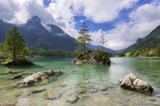 Hintersee near Ramsau with clear green water, surrounded by forests and mountains under a cloudy