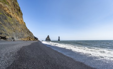 Black beach with cliffs, rock Reynisdrangar in the water, at Reynisfjara beach, Vik, South Iceland,