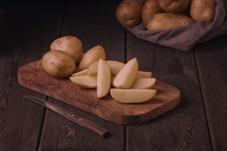 Raw potatoes, sliced, on a wooden table, top view, no people