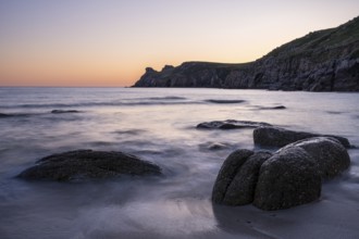 Coastal landscape. Rocks in the sea. In the evening after sunset. Long exposure. Nanjizal Bay, St