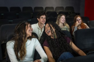 Friends enjoying laughter together while watching a comedy film at the cinema, sharing moments of