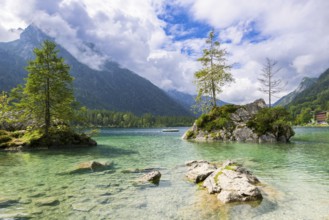 Hintersee near Ramsau with clear green water, surrounded by forests and mountains under a cloudy