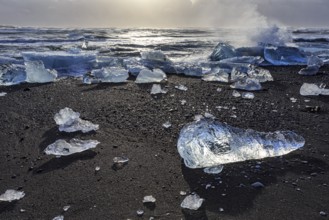 Ice floes on the beach, waves, sea, clouds, sunlight, winter, Diamond Beach, Breidamerkursandur,