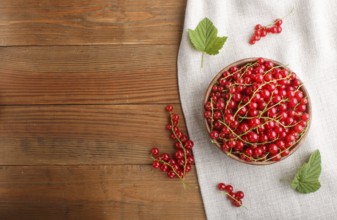 Fresh red currant in wooden bowl on wooden background. top view, flat lay, copy space