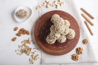 Energy balls cakes with almonds, sesame, cashew, walnuts, dates and germinated wheat on wooden