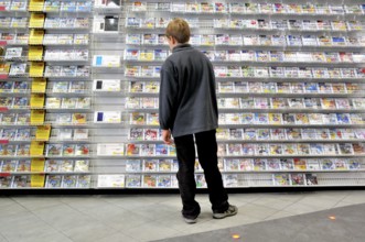 Ten-year-old boy in a shop with a surplus of Nintendo DS games, Germany, Europe