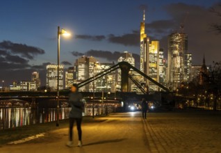 Skyline of the city centre of Frankfurt am Main, joggers on the pavement, promenade along the river