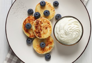 Cottage cheese pancakes, with blueberries, breakfast, on a white wooden table, no people, top view