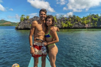 Couple enjoying a snorkeling trip in coron island, philippines, embracing on a traditional bangka