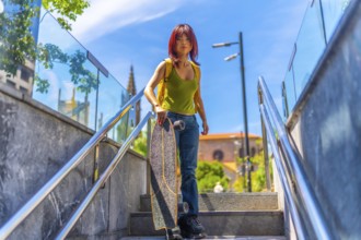 Urban portrait of a chinese young woman holding skateboard standing upstairs in the city