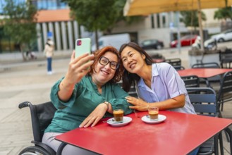 Woman with disability and asian female friend taking selfie in an outdoor cafeteria