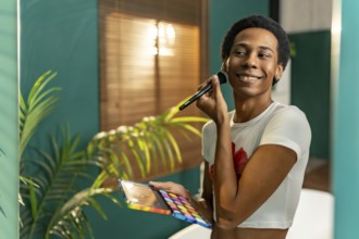 Reflection in the mirror of a transgender young latin man making up at home