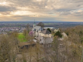 Panoramic view of a church with a view of the village and a cloudy landscape in the background,