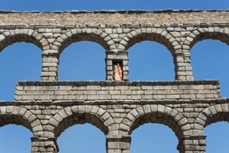 Close-up of a stone aqueduct with several arches under a clear blue sky in Segovia, Aqueduct,