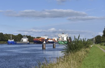 Cargo ship and container ship meet in the Kiel Canal, Kiel Canal in a ship siding,